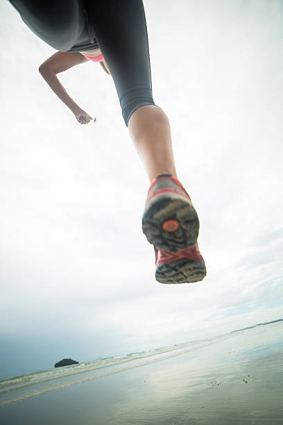 niski kąt widzenia kobieta działa na plaży - jumping women running vitality zdjęcia i obrazy z banku zdjęć