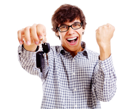 Screaming young man with car keys and raised fist isolated on white background