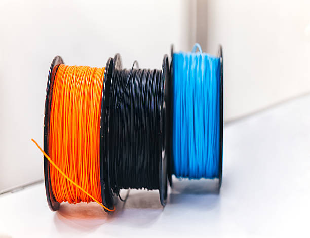3D printer welding rods Three color (black, orange, blue) Three diamensional 3D printer filament PLA/ABS/PVA/HIPS thermo plastic welding rods rools on table 3d printing filament photos stock pictures, royalty-free photos & images