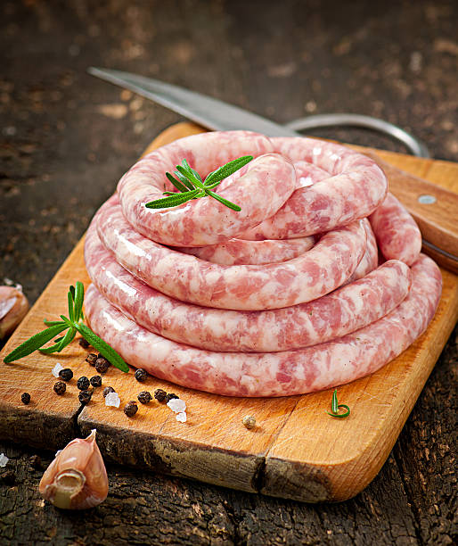 istock Fresh raw sausage on the old wooden background 477434525
