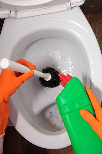 istock Gloved hand cleaning toilet bowl using brush 477435171