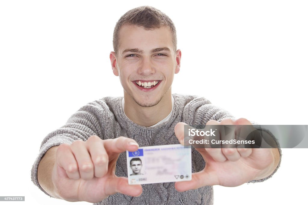 Young man showing his driver license 16 to 18 year old boy just received his driver license Driver's License Stock Photo