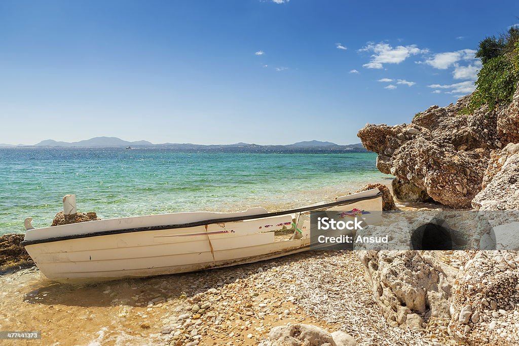 Destoyed fishing boat at rocks under bright sunlight Destroyed fishing boat at rocks under bright sunlight at Ionian sea, Corfu, Greece Aegean Sea Stock Photo