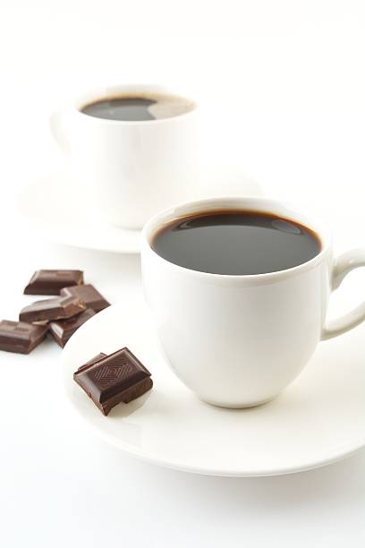 istock Cups of coffee with chocolate and saucers on white 477441420