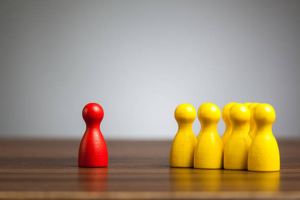 istock Red pawn figure against united yellow, isolation, confrontation, 477443825