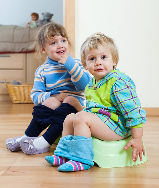 istock children  sitting on chamber pots 477445483