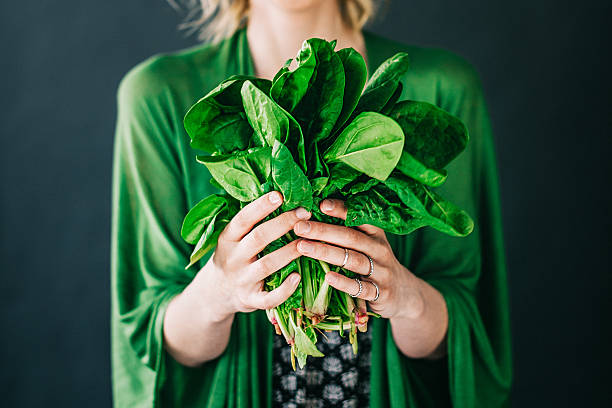 istock Young woman holding spinach leafs salad 477445768
