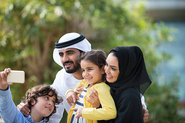 tradizionalmente in medio oriente famiglia in posa per un selfie in park - ghoutra foto e immagini stock