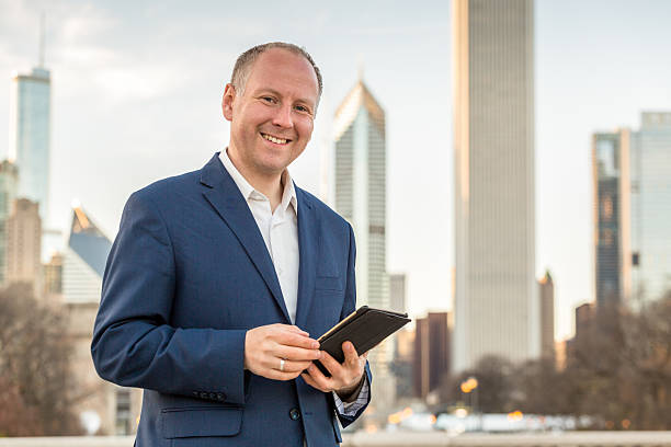 istock Businessman with tablet in front of office buildings 477446078