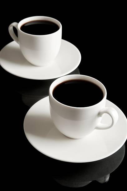 copos de café com pires isolado no preto - two objects cup saucer isolated imagens e fotografias de stock