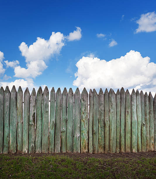 istock Old wooden fence against blue sky with clouds. Background 477451328