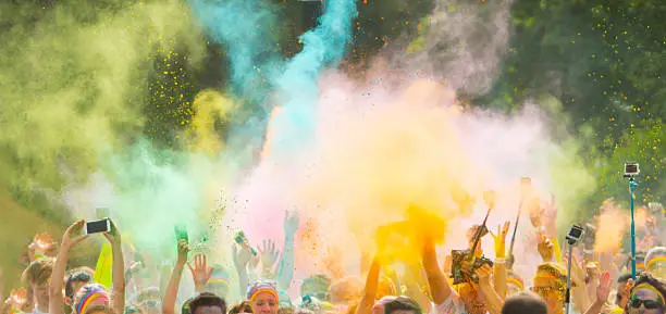 Colorrun competitors in detail of hands throwing colored powder