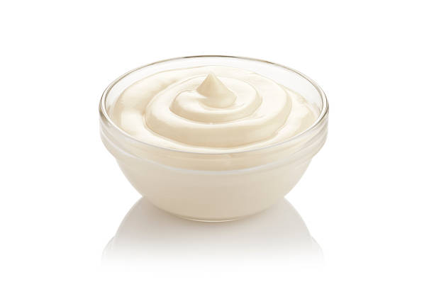 istock Mayonnaise in a glass bowl on reflective white background 477458432