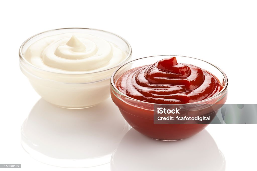 Ketchup and mayonnaise in a bowls isolated on white background Ketchup and mayonnaise in a bowls isolated on white background. DSRL studio photo taken with Canon EOS 5D Mk II and and Canon EF 70-200mm f/2.8L IS II USM Telephoto Zoom Lens 2015 Stock Photo