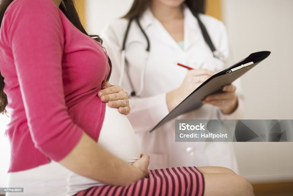 Pregnant woman with doctor Young pregnant woman with doctor in ambulance. Pregnant Stock Photo