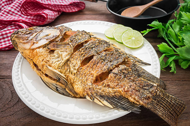 istock Fried fish on plate with vegetables and pan 477463902
