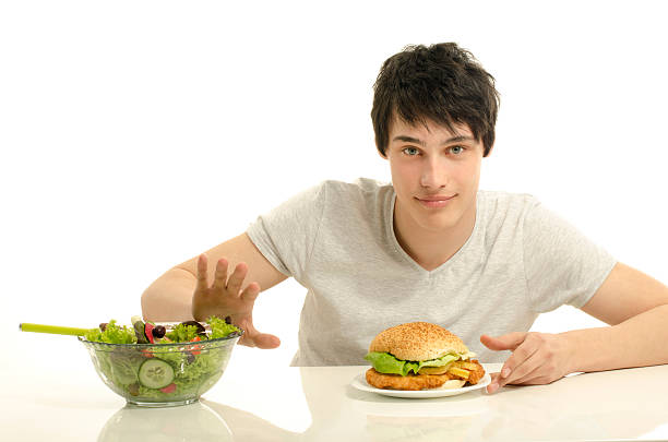 istock Man choosing between a bowl of salad and big hamburger. 477464300