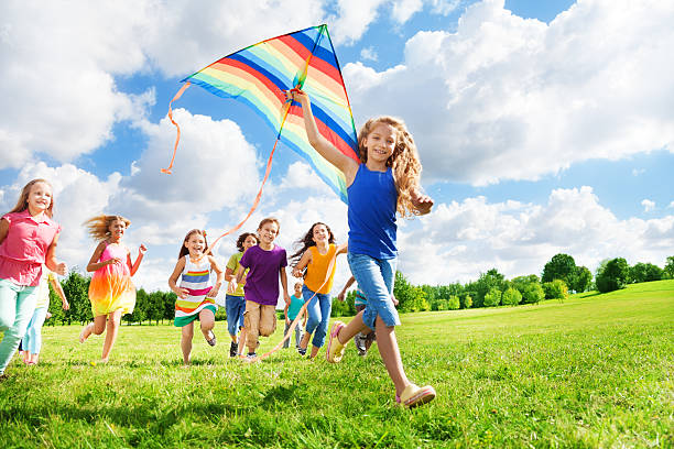 istock Cool girl with kite and her friends 477466475