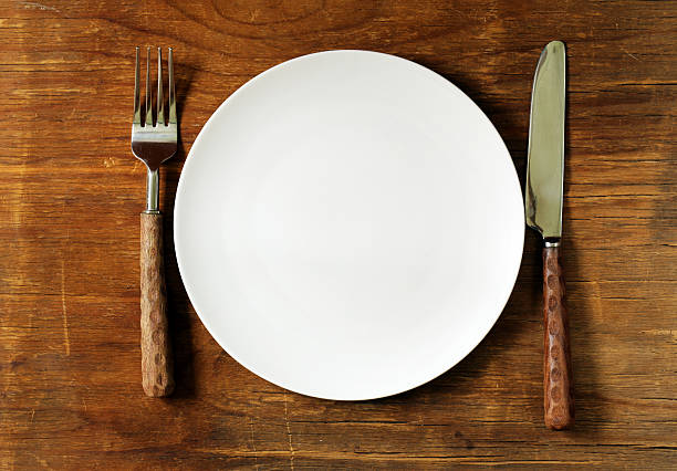 istock empty plate with cutlery and napkin on wooden background 477468166