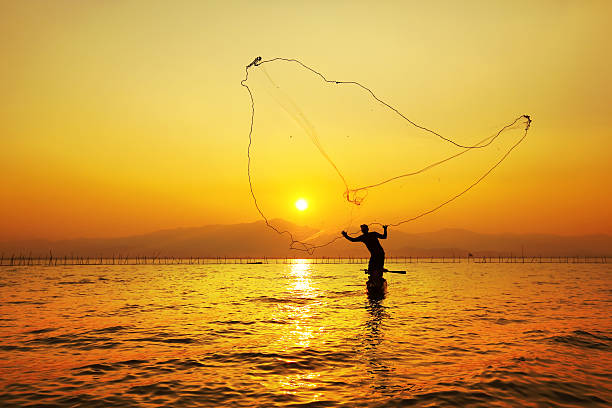 istock throwing fishing net during sunset , thai 477469659
