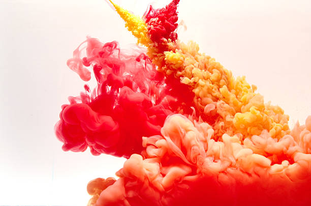 istock Red and yellow inks making clouds in water 477469760