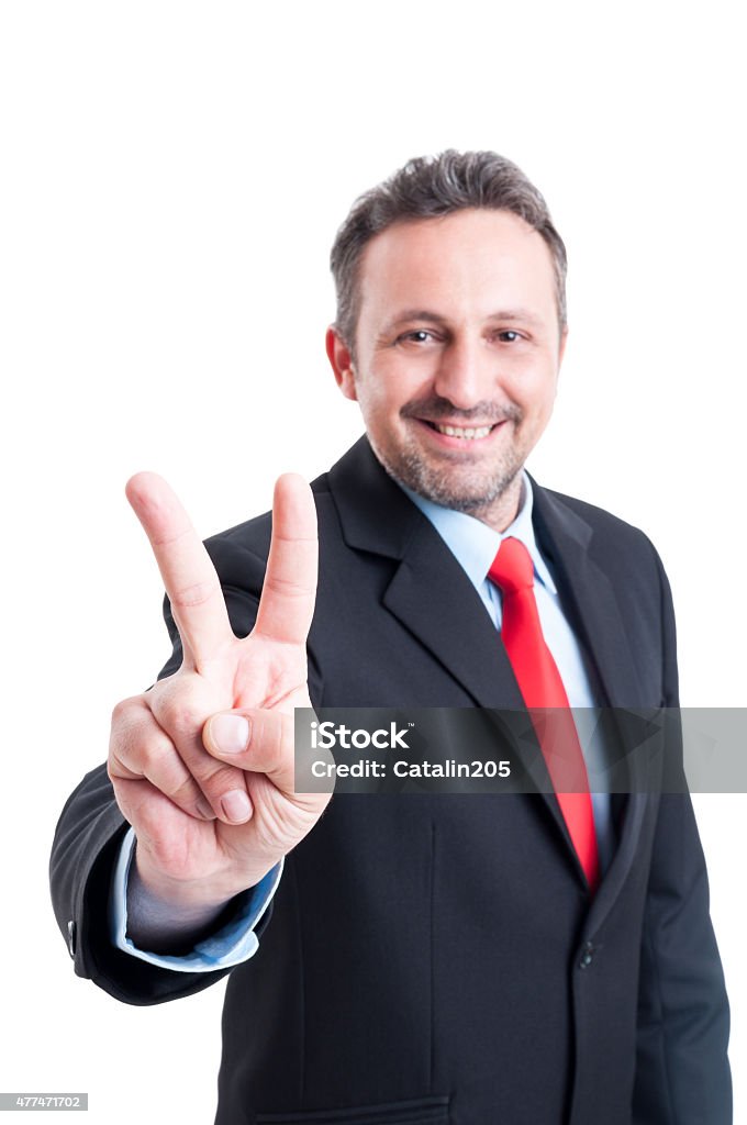 Business man showing victory sign or gesture Business man showing victory sign or gesture while smiling confident like a winner 2015 Stock Photo