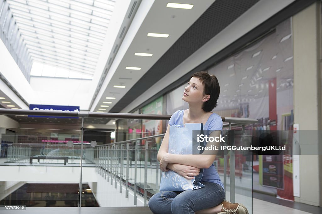 Mulher com Saco de Papel olhando para cima em Shopping Centre - Foto de stock de Adulto royalty-free