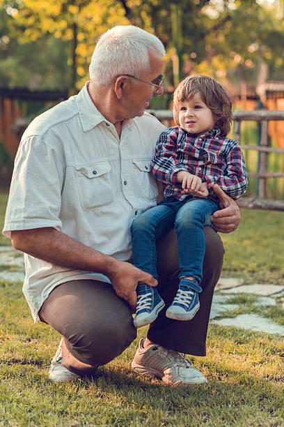 istock Grandfather and grandson talking to each other outdoors during springtime. 477474192