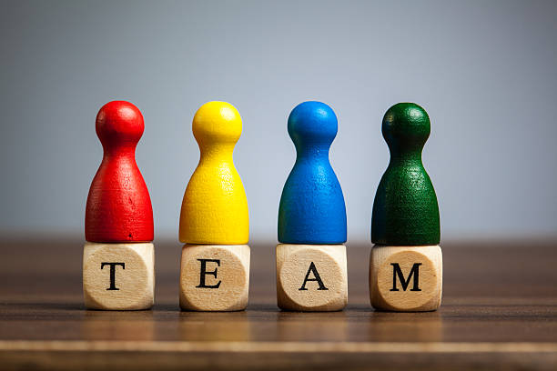 istock Four pawn figurines, team concept, table, grey background 477475099