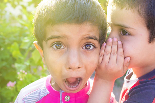 istock Little boy whispering something his friend's ear 477475770