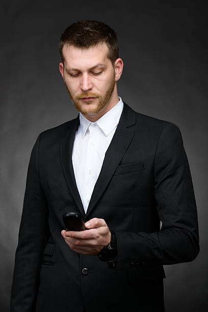 istock young business man looking at phone 477477117