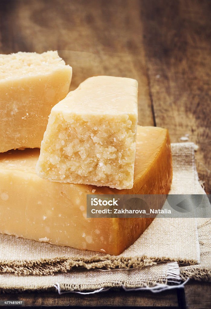 Italian  Parmesan Cheese on Wooden Background close up. Italian  Parmesan Cheese on Wooden Background close up. Piece of Parmigiano  cheese on a napkin, rustic style. Backgrounds Stock Photo