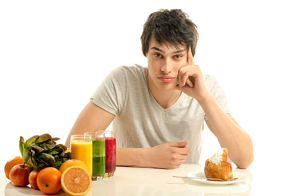 istock Man choosing between healty fruits and unhealthy cake. 477482362