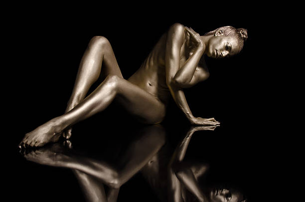 Golden Reflection Nude gold body painting on black background naked stock pictures, royalty-free photos & images