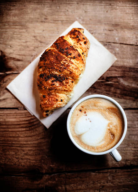 istock Coffee and fresh croissant for breakfast on rustic wooden table, 477485316