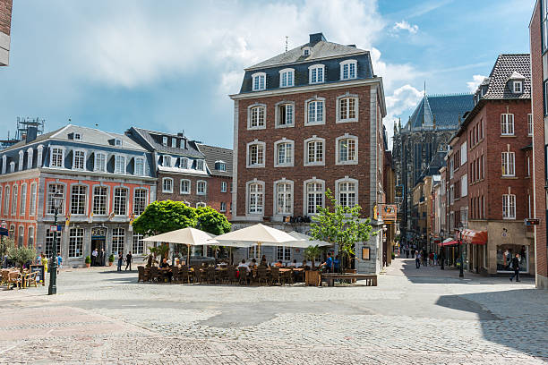 Aachen, Germany - May 20, 2012: Historic city centre of very old town Aachen in Germany. Lot of pubs with many people in narrow alleys. Most of buildings have brickwalls  and most streets have cobblestones.