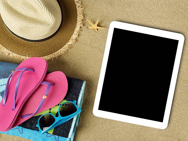 istock Tablet and beach accesories on sand 477488052