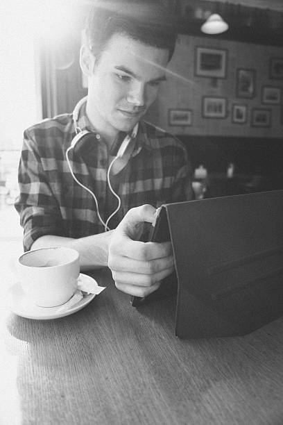 Cheerful Young Man Using Tablet In Coffee Shop