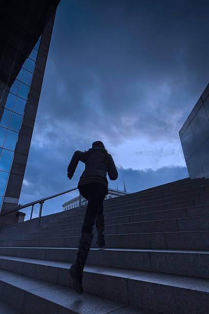 Woman running up city steps stock photo