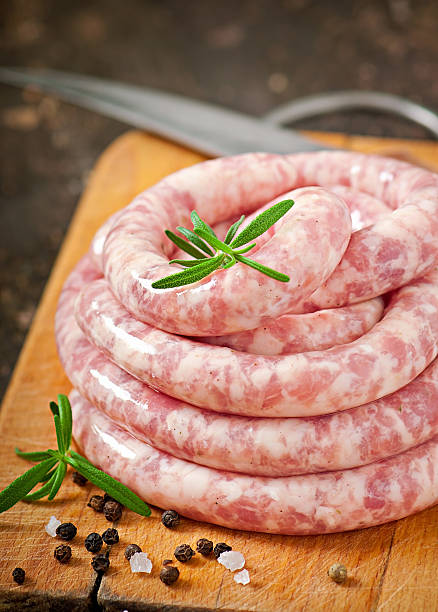 istock Fresh raw sausage on the old wooden background 477494525