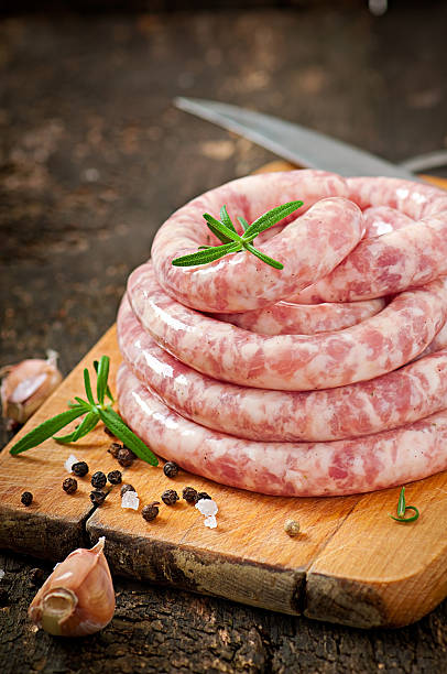 istock Fresh raw sausage on the old wooden background 477495337