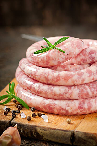 istock Fresh raw sausage on the old wooden background 477495785