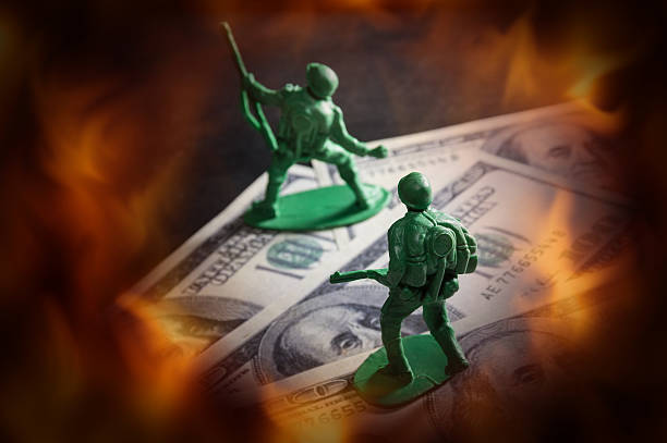 istock Soldier toys on money with fire screen. 477499176