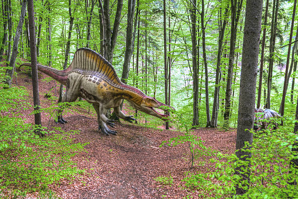 istock The lost world - dinosaurs forest. Boy fighting a dinosaur 477500444
