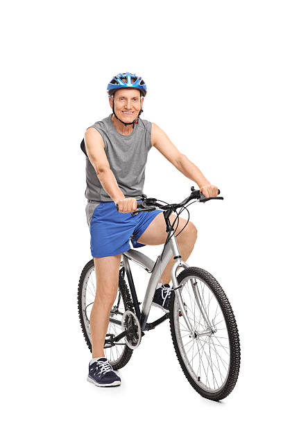 istock Senior with a blue helmet posing on a bicycle 477503536