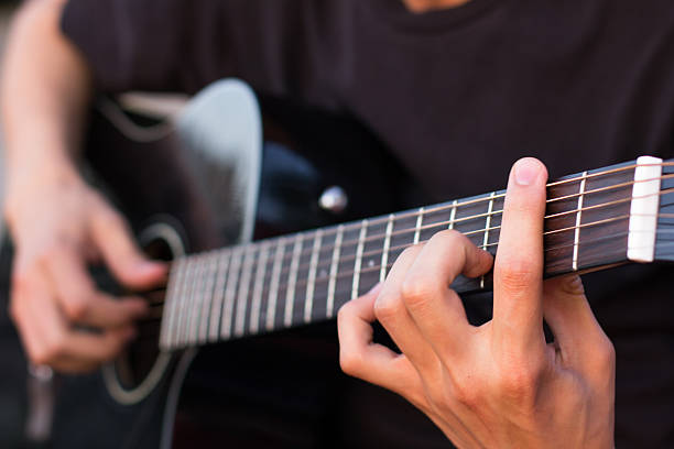 istock young man playing an acoustic guitar on the beach 477504098