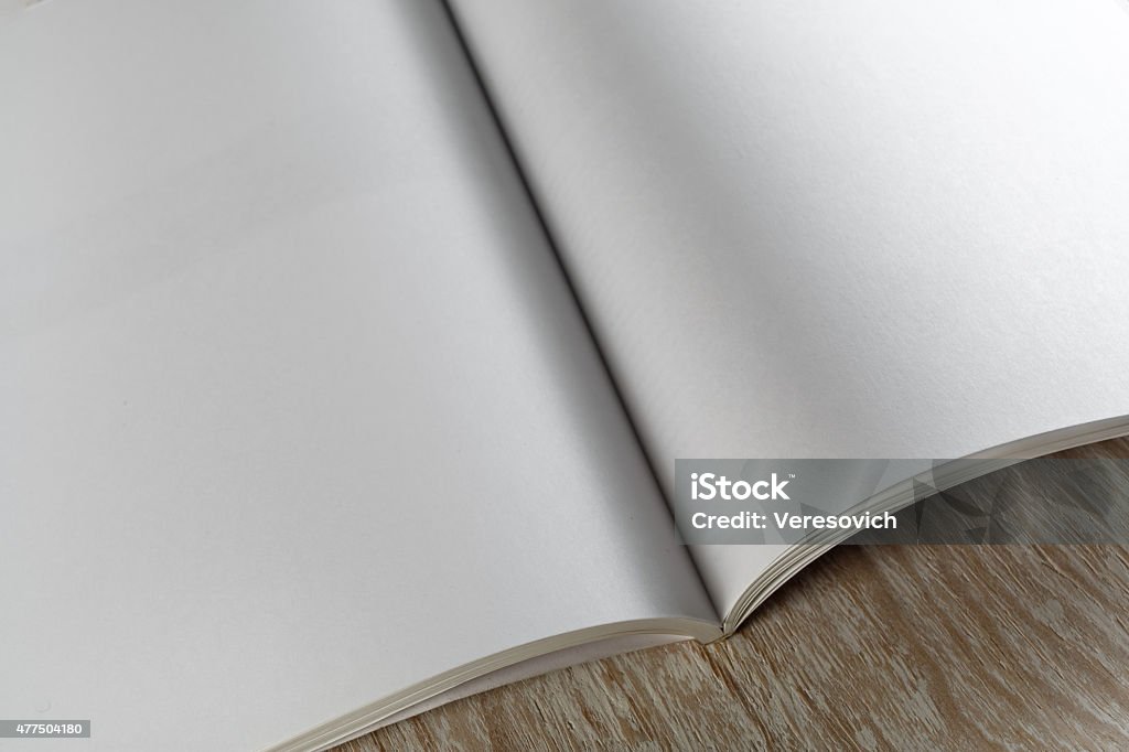 Fragment of blank magazine Fragment of blank opened magazine on light wooden background with soft shadows close-up. For design presentations and portfolios. Artificial Stock Photo