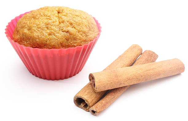 Hand with red glove taking pan with six chocolate muffins from the oven