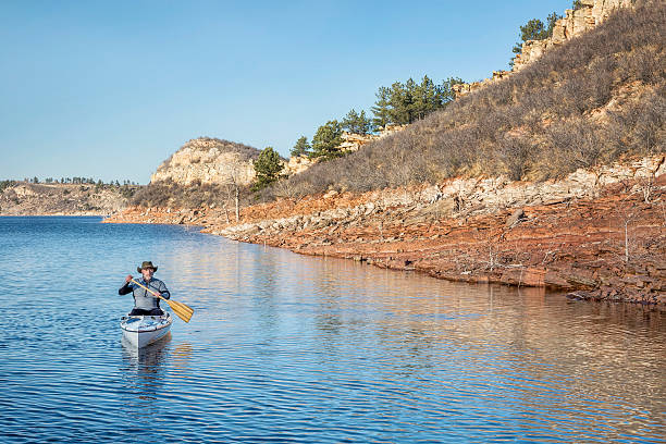 istock senior male paddling canoe 477516602