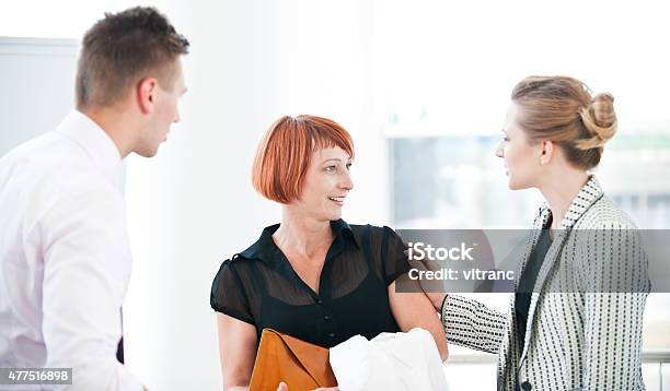 Salesman And Two Customer Stock Photo - Download Image Now - 20-24 Years, 2015, Adult